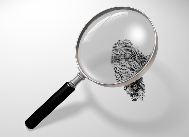 Stock image of a magnifying glass over a fingerprint.